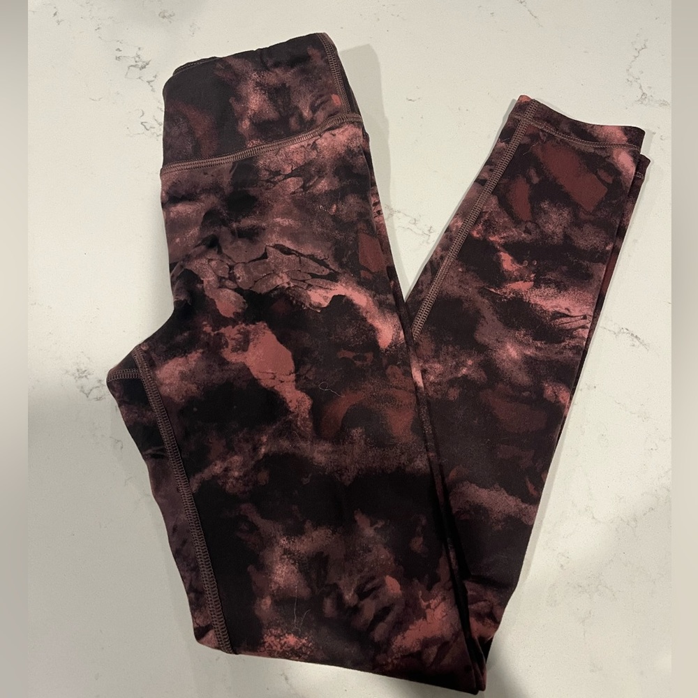 Girls Athleta leggings size Med- 8/10. Color is a camo/marbled black and rust.